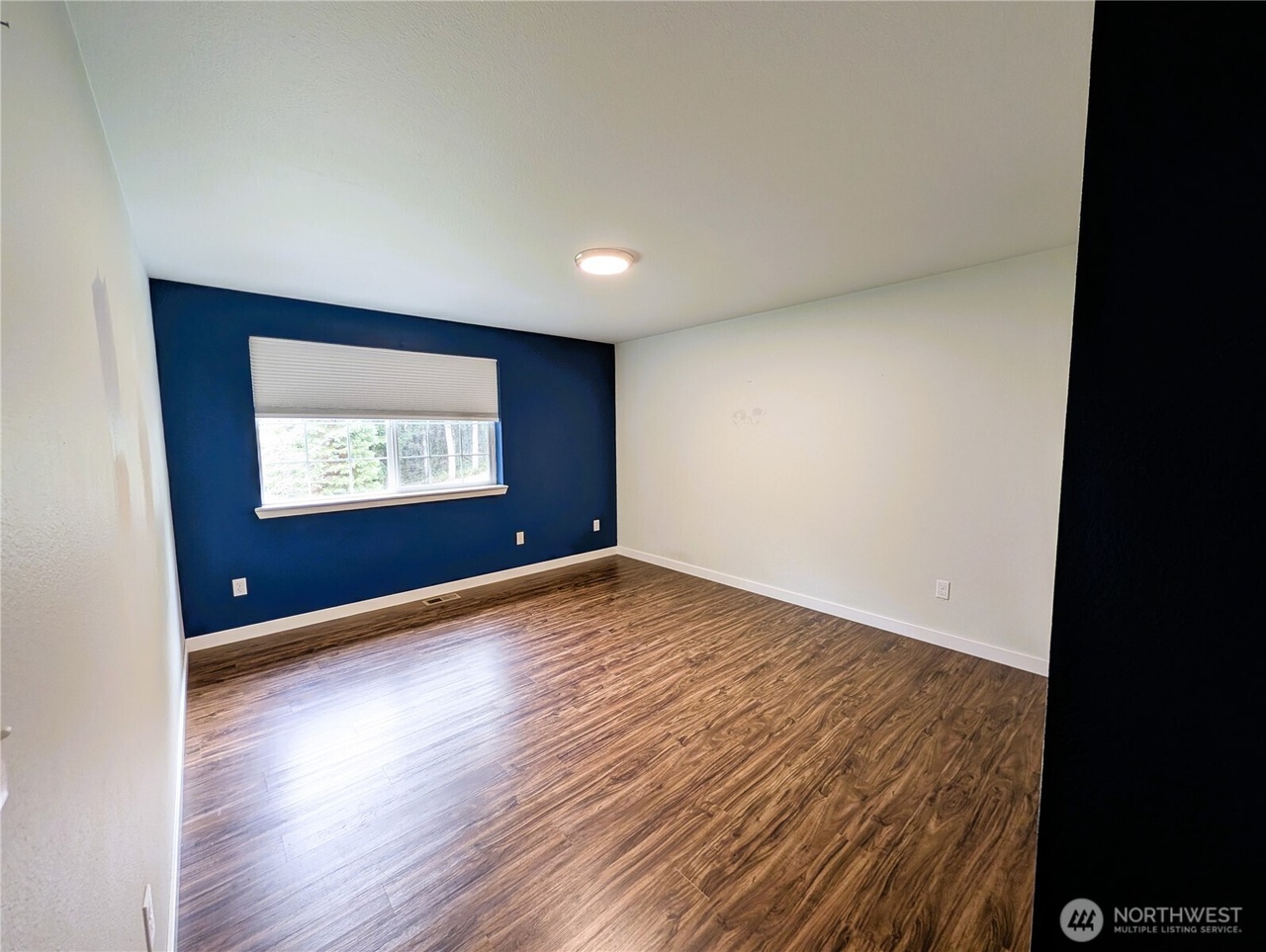Bedroom with navy blue accent wall and tree view